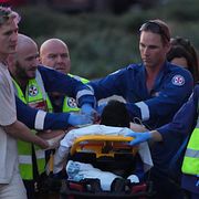 Ambulanspersonal hjälper en person som skadats i dådet.