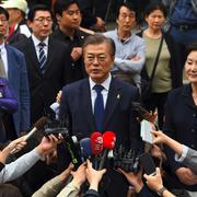 Moon Jae-In och hans fru Kim Jung-Suk vinkar efter att ha röstat i Sydkoreas presidentval. 