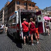 Ambulanspersonal i Rom hjälper turister i värmen nära Spanska trappan i Rom (1 juli)