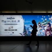  Commuters walk by a computer and mobile phone's RPG games advertised at a subway station in Beijing Tuesday, Sept. 14, 2021.