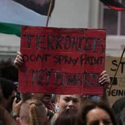 Demonstranter protesterar mot anklagelserna mot Palestine action på måndagen. Terrorister sprejmålar inte, de bombar barn, står det på skylten.