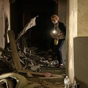 En kvinna inspekterar sin lägenhet som förstörts i en rysk attack mot Kyiv.
