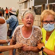 An elderly woman is evacuated during a wildfire in Veiga das Meas, northwestern Spain, Saturday, Aug. 16, 2025. (AP Photo/Lalo R. Villar)  MF118