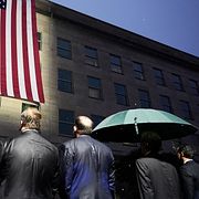 Försvarsminister Pete Hegseth ser en flagga vecklas ut på försvarshögkvarteret Pentagon tillsammans med andra högt uppsatta militärer.