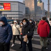 Illustrationsbild. Människor går över en gata i Beijing, 10 februari 2023. 