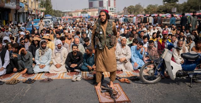 En medlem i talibanerna i förgrunden och afghanska män i bakgrunden i samband med fredagsbönen i Kabul i går. Bernat Armangue / TT NYHETSBYRÅN