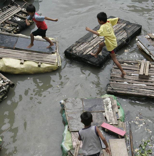 Filipino children play on improvised floats along a still submerged town of Taytay, Rizal Province, Philippines, after typhoon Ketsana in 2009. Aaron Favila / AP
