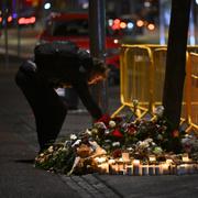 Sörjande lämnar blommor och ljus på olycksplatsen.
