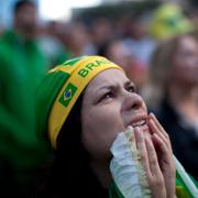 A fan of Brazil reacts as she watches as the Netherlands scores a goal in a penalty shot against Brazil, during the match for the third place finish of the World Cup, at the FIFA Fan Fest in Sao Paulo, Brazil, Saturday, July 12, 2014. 