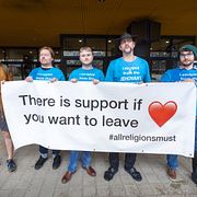 Viktor Astner, Jerry Juhjalahti, Jacob Harris, Jonas Skogstroll och Sylas Shaw demonstrerar mot Jehovas vittnens ägare under ett konvent för Jehovas vittnen på 3 Arena i Stockholm.