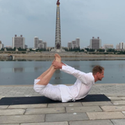 Joachim Bergström gör yoga med Juchetornet i bakgrunden.