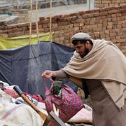 En man letar i rasmassor i Afghanistans huvudstad Kabul.