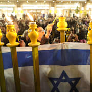 Ran Gvilis mamma tänder ett ljus under en demonstration i Tel Aviv. Bild från december. 
