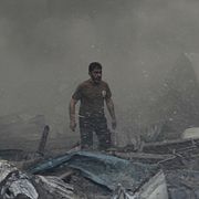 En person står i rasmassorna av ett hus i Beirut efter Israels attackvåg på onsdagen.