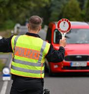 En tysk polis stoppar en bil i jakt på männsikosmugglare under måndagen.  Patrick Pleul / AP