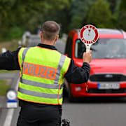 En tysk polis stoppar en bil i jakt på männsikosmugglare under måndagen.  Patrick Pleul / AP