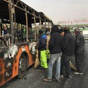 Iranier inspekterar en nedbrunnen buss.