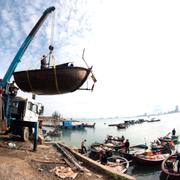 Människor flyttar fiskebåtar inför evakuering i Danang, Vietnam