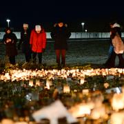 Människor tänder ljus på minnesplatsen utanför Campus Risbergska i Örebro där tio personer dödades.