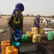 Arkivbild: En kvinna tillhörande den nomadiska folkgruppen Fulani samlar vatten till sin familjs boskap vid en brunn i Gadabeji, i Nigerias grannland Niger.