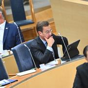 Liberalernas partiledare Johan Pehrson (L) och statsminister Ulf Kristersson (M) lyssnar på Sverigedemokraternas partiledare Jimmie Åkesson (SD) vid partiledardebatten i riksdagens kammare under onsdagen. 