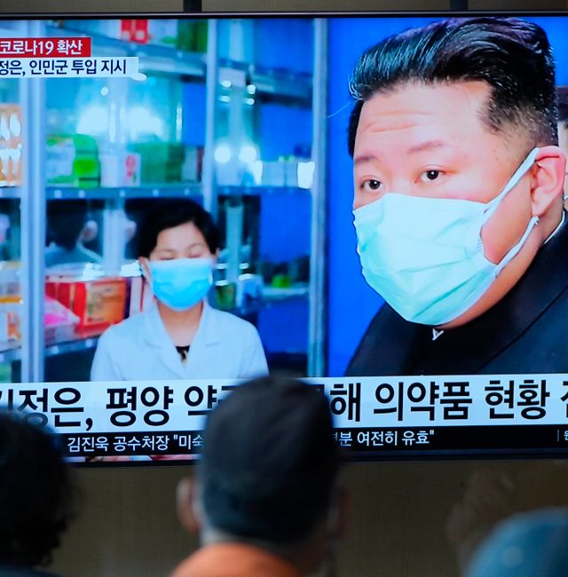 People in Seoul watch a TV screen showing a news program reporting with an image of North Korean leader Kim Jong Un. Lee Jin-man / AP