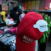 Vendor Duane Jackson completes a sale of "Make America Great Again" caps, that are made in China, at his location in New York's Times Square on April, 2025.