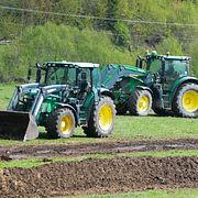 Bönder sprider gödsel med traktor. Illustrationsbild.