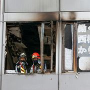 Brandmän i den branddrabbade byggnaden. 