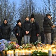 Sörjande samlas för att placera blommor och ljus utanför Risbergska skolan i Örebro dagen efter skolskjutningen där minst 11 personer miste sina liv.