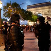 Poliser talar med en ungdom vid Triumfbågen i Paris. Christophe Ena / AP