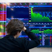 Stockholmsbörsen. En man står framför en skärm med dalande aktiekurser.