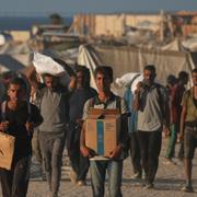 Palestinier bär på nödhjälp under söndagen.