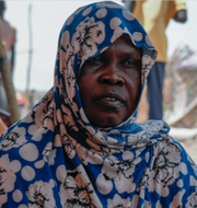Kvinna som tvingats på flykt från Sudan/karta över Darfur och Tchad.