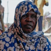 Kvinna som tvingats på flykt från Sudan/karta över Darfur och Tchad.