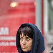 En kvinna passerar en poster för kommunistpartiet