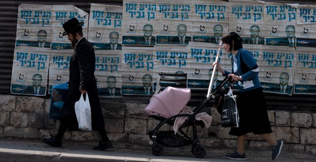 Ultraortodoxt par i Bet Shemesh i Israel passerar valaffischer för Itamar Ben Gvir. Maya Alleruzzo / AP