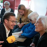 Moderaternas partiledare Ulf Kristersson (M) samtalar med Dagny Olsson, 110 år, vid ett boende i Umeå under en bussturné.