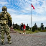 En rysk soldat vid ett krigsmonument för andra världskriget i staden Cherson, som ockuperats av Ryssland sedan krigets inledande dagar. 