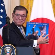 Japans premiärminister Shigeru Ishiba håller i en bok han fick av Donald Trump. 