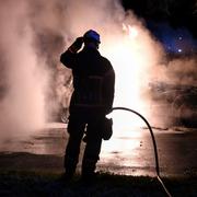 Räddningstjänsten släcker en brinnande bil i Malmö. 