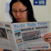 En hotellreceptionist i Tamuning i Guam läser om Nordkoreakrisen i tidningen Pacific Daily News. 