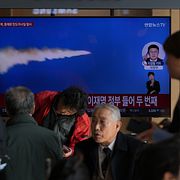 Arkivbild. Människor tittar på ett tv-inslag om ett nordkoreanskt robottest  i Seouls tunnelbana.