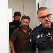 Saif Abukeshek eskorteras till förhör.
