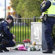 Poliser vid minnesplatsen för de tre mördade personerna. 