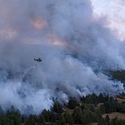 En helikopter vattenbombar en skogsbrand i Serbien.