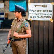 En polis vaktar en vallokal i Sri Lanka.