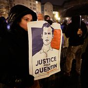 En kvinna håller ett plackat på Quentin Deranque.