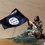 En man poserar med en IS-flagga i den syriska staden Raqqa i augusti 2014. Bilden har ingen koppling till innehållet i artikeln.