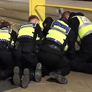 Polisen gör ett gripande på platsen efter händelsen.